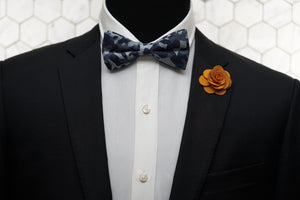 A model wearing Dear Martian, products which include a camo novelty bow tie and orange flower lapel pin.