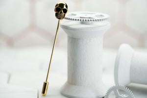 An image of a gold skull suit jacket pin named the Vie by Dear Martian.