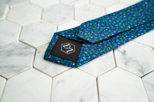 The back of the Dear Martian, Ditsy skinny floral purple tie, featuring a hexagon DM stitched logo.