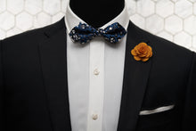 An image of a mannequin styled in Dear Martian products like the diamond pointed Crooke bow tie, white linen handkerchief, and orange flower lapel pin.