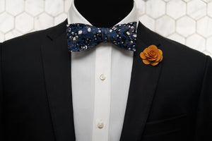 A mannequin rocking an edgy look with the Spotted Steel Blue cotton bow tie and contrasting with a vivid orange lapel pin.