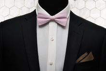 An image of a fitted men's suit with our exclusive pink bow tie and matching brown pocket square.