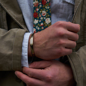 Image of the brass cuff bracelet and Posie floral tie by Dear Martian, Brooklyn.