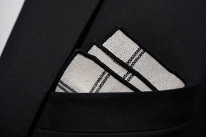 Dear Martian's Lexington Ave white linen argyle pocket square with black border is shown with a three-point fold. 
