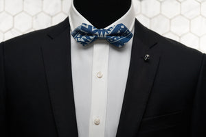 A mannequin is shown wearing our Heisser Triangle  denim bow tie with gold skull lapel pin.