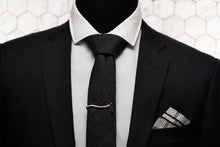 Men's accessories from Dear Martian are displayed on a mannequin which features a black chambray tie, axe tie clip, and argyle linen pocket square.