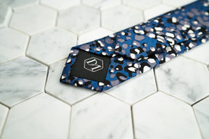 The back of the navy dotted skinny tie by Dear Martian, features a stitched DM hexagonal logo.