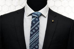 Our Dear Martian, handmade denim skull patterned tie is displayed on a mannequin featuring our Vie gold skull lapel pin. 