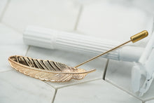 The front image of the Veder gold plated lapel pin by Dear Martian. the lapel pin has a detailed feather shape.