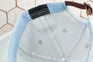 A detailed image portraying the inside panel of the denim hat, which features a Dear Martian, Brooklyn label with inside logo taping.
