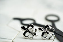 A pair of steel plated fleur de lis mens accessory cufflinks made by Dear Martian, Brooklyn.