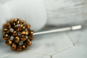 Front image of the copper tone beaded suit lapel pin by Dear Martian, which features rhinestones for an extra shine.