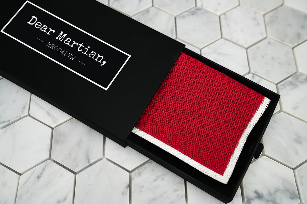 An image of the knitted red handkerchief inside the Dear Martian, Brooklyn black pull out style box.