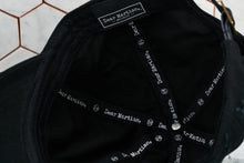 A detailed photo of the inside view of the black hat, which shows the Dear Martian, Brooklyn logo and inner taping.