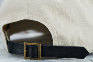 A detailed shot of the Dear Martian, optional pointed leather strap, which features a brass belt buckle.