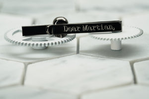 The back image of the gunmetal Vie skull tie clip that depicts the Dear Martian logo engraving.