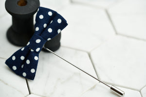 A side view image of the Dalmation bow shaped lapel pin by Dear Martian, which features a navy and white spotted canvas.