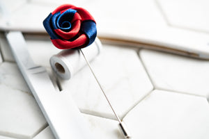 A handmade satin flower lapel pin with red and navy colors constructed by Dear Martian.