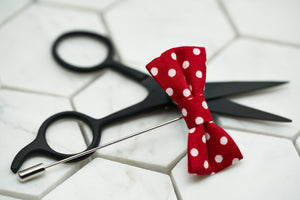 A photo of the Dear Martian white and red polka dot mini bow tie lapel boutonniere.