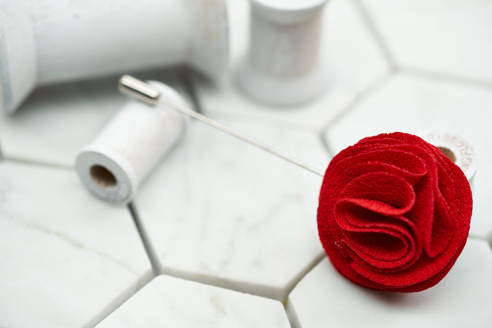 An image of the groomsmen vivid red flower lapel pin handmade by Dear Martian.