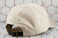 A back view of the tan dad hat by Dear Martian Brooklyn, which shows the leather belt buckle strap.