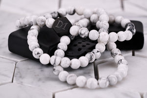 An image of the Dear Martian, BKLYN white howlite wrap bracelet , which features a matte black hexagon logo bead.