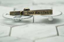 The back of the vintage brass Vie Skull tie bar, which features the Dear Martian, logo etched in.