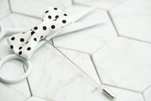 A top view image of the Dalmatian black and white spotted mini bow tie lapel pin by Dear Martian.