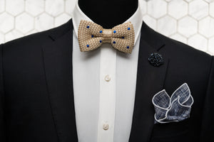 A mannequin is shown wearing a black suit wit our kahki & blue dotted silk knitted bow tie, navy patterned bow tie and matching navy floral lapel pin.