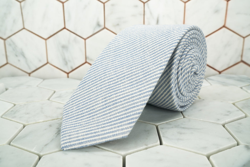 A DM exclusive pencil striped linen neck tie; featuring thin grey and white stripes.