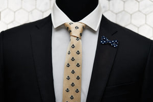The Dear Martian ivory necktie with embroidered anchors is shown on a mannequin with a suit. The suit features a mini bow polka dot lapel pin.