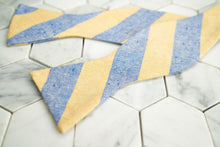 An image of the Dear Martian yellow and blue striped linen bow tie; lying flat and untied.