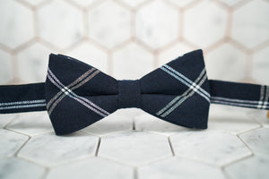 A front image of a minimalist navy bow tie featuring white stripes and a navy background.
