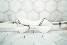 A front image of the Dear Martian Lexington ave white argyle pre-tied bow tie sitting against a white hexagonal background.