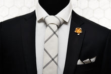 The Lexington Ave necktie is knotted in a half windsor and paired with a rose gold lapel pin and matching white linen pocketsquare made by Dear Martian.
