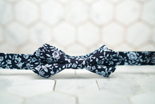 A DM exclusive diamond-pointed bow tie that has a colorful navy floral print.