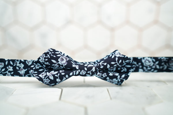 A DM exclusive diamond-pointed bow tie that has a colorful navy floral print.