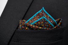 An image of the Ditsy floral pocket square by Dear Martian is show folded in a suit pocket.