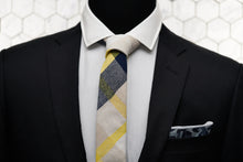 A men's black suit is paired with Dear Martian's collage patterned tie and camo blue denim pocket square.