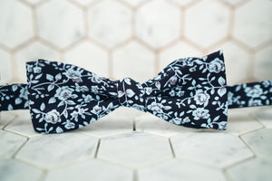 A self-tie bow tie by Dear Martian, Brooklyn, which features an array of flowers against a navy canvas.