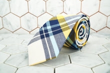 A men's cotton plaid tie from Dear Martian, Brooklyn is rolled up.