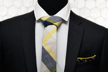 A men's black suit is paired with Dear Martian's collage patterned tie and floral pocket square.