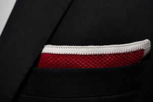 A close-up image of Dear Martian's knitted red pocket square against a black suit jacket.