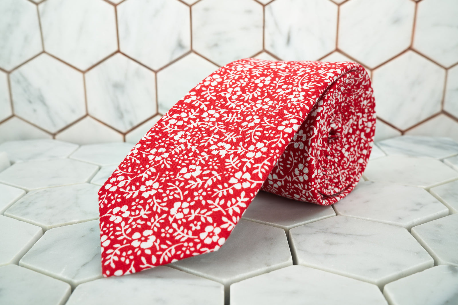 A Dear Martian exclusive floral necktie, featuring an array of white flowers on a vivid red canvas. 