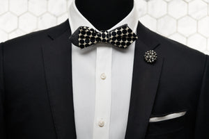 A mannequin dressed in a black and white polka dot bow tie with our DM rhinestone lapel pin and matching pocket square.