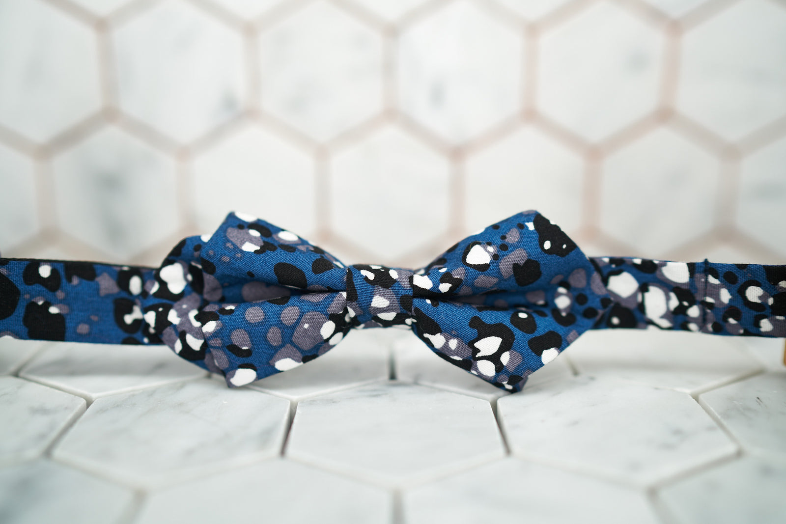 The front of the navy DM jaguar printed diamond pointed bow tie.