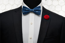 An image of a patriotic mannequin dressed in red, white and blue by accessorizing with Dear Martian products, which include a denim patterned bow tie and red floral lapel pin.