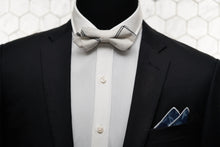 An image of a mannequin styled in Dear Martian accessories and a black suit jacket. Donning a diamond pointed white bow tie and cranford floral pocket square; the mannequin looks dapper.