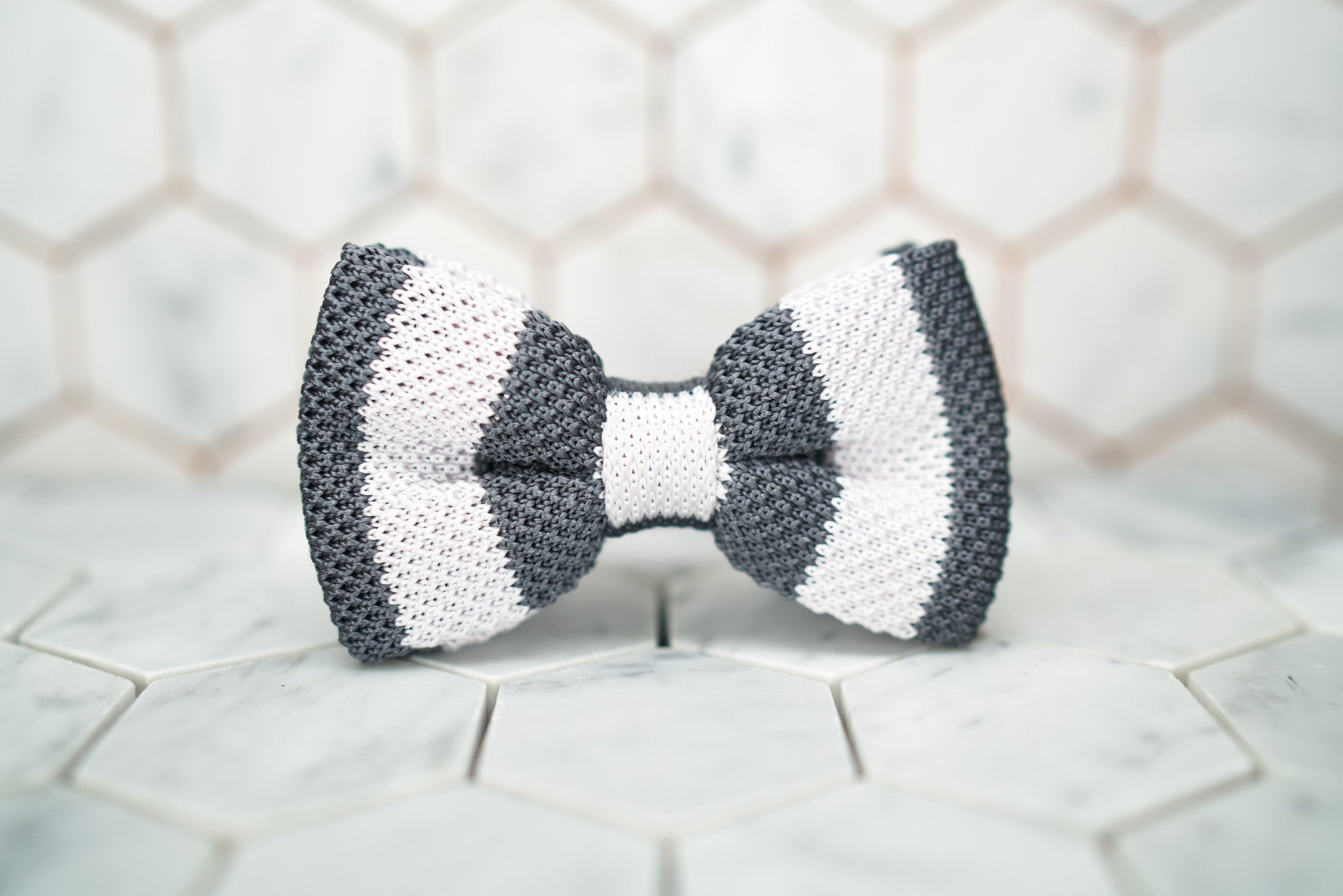 A front image of the silk knitted Dear Martian bow tie, which feature grey and white stripes.