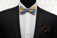 A mannequin is modelling Dear Martian's bow tie with yellow and blue stripes; and a matching floral pocket square.